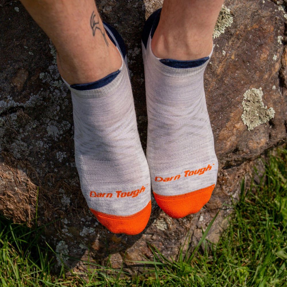 Men's ash no-show running socks shown worn on feet outdoors, close-up