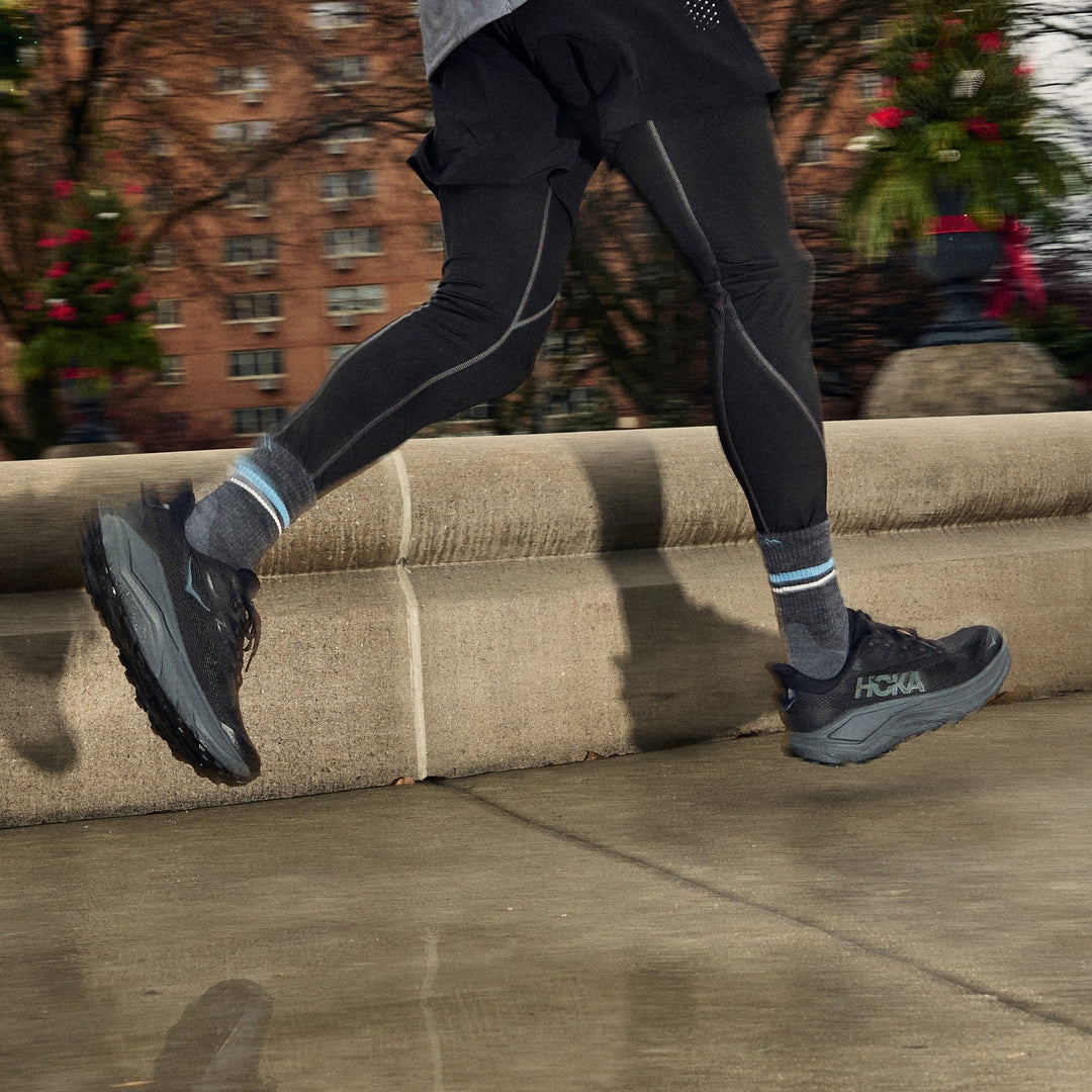 Man running on a wet city sidewalk wearing men&