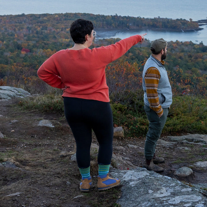 Woman pointing into the distance while hiking, wearing women&