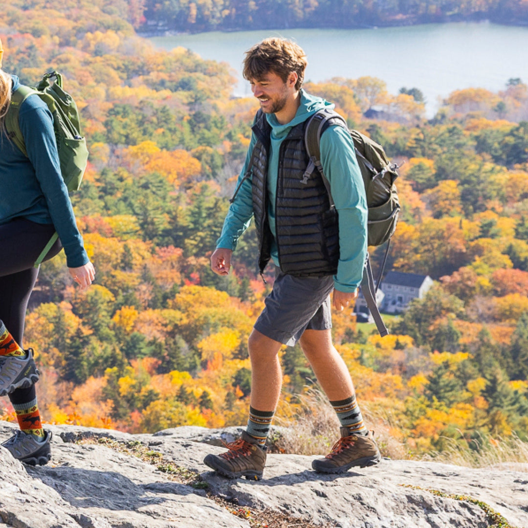 Man hiking with autumn foliage behind him wearing men&
