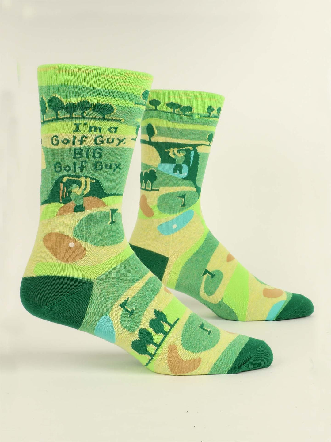 Blue Q’s “I’m A Golf Guy. BIG Golf Guy.” M-Crew Socks are green, combed cotton socks featuring playful golf course graphics, a golfer illustration, and text—including a triple bogey—printed across the design.