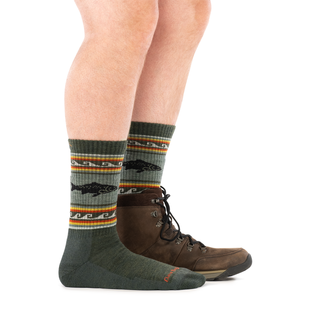 Side profile of a man wearing a hiking boot on one foot and men&
