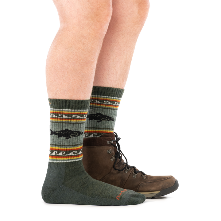 Side profile of a man wearing a hiking boot on one foot and men&