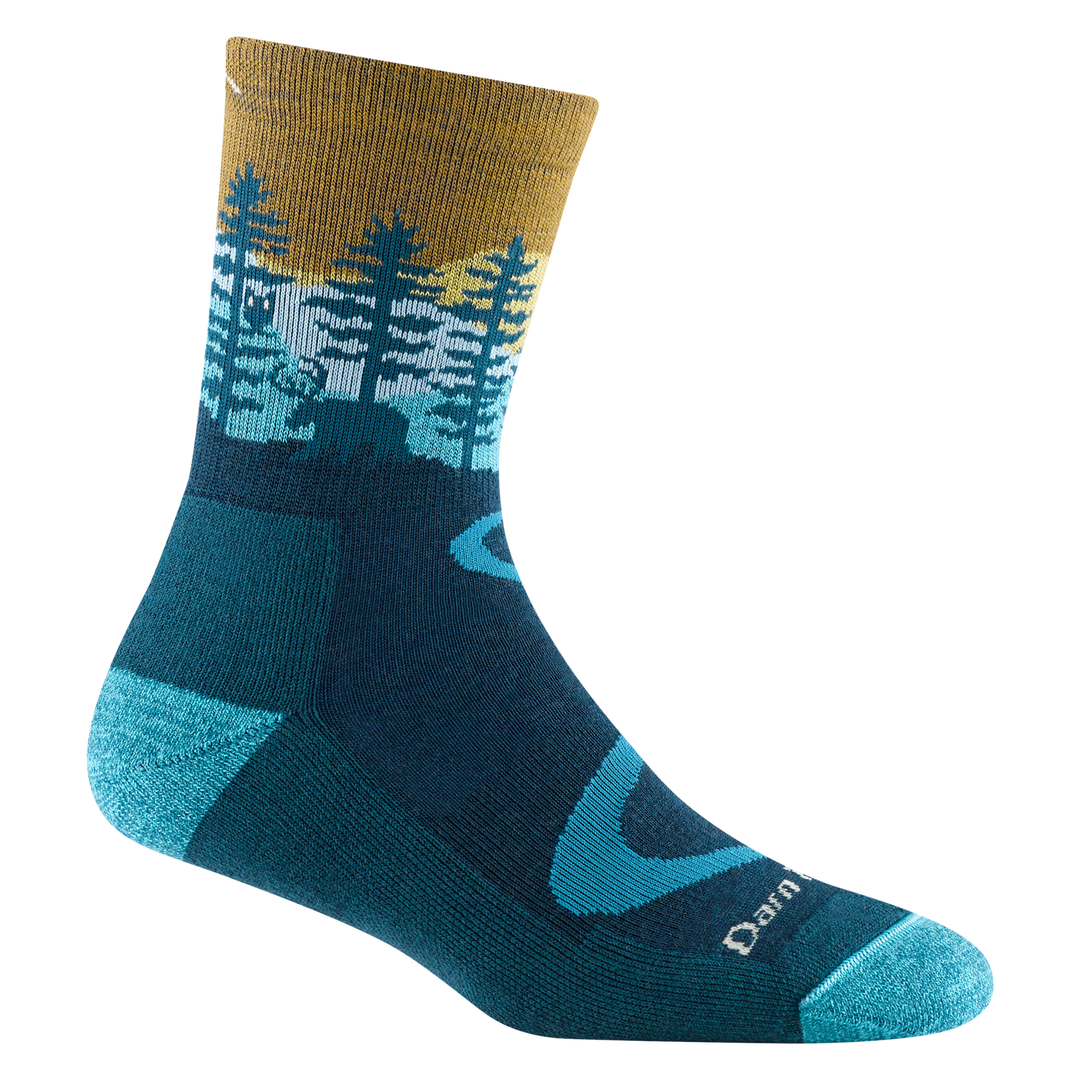 Women's dark teal northwoods micro crew sock, flat side view with pine forest and sunrise design