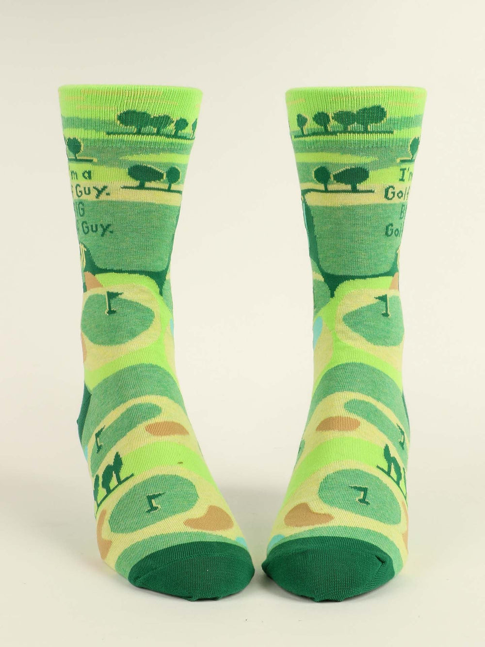 Blue Q’s I'm A Golf Guy. Big Golf Guy. M-Crew Socks are green combed cotton socks featuring golf course designs and the playful text: I’m a Golf Guy, BIG Golf Guy—perfect for adding fun style to your game.