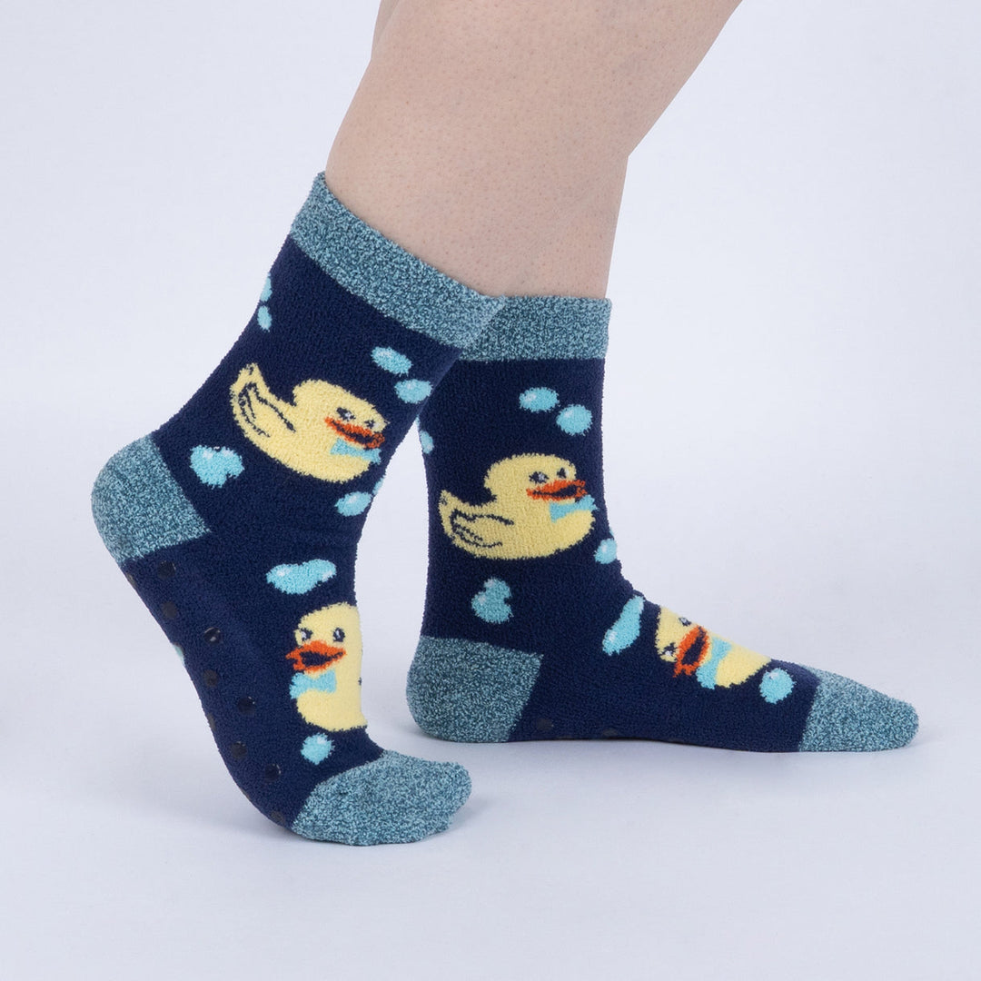 Women's fuzzy rubber duck slipper socks worn, side view showing yellow ducks on navy
