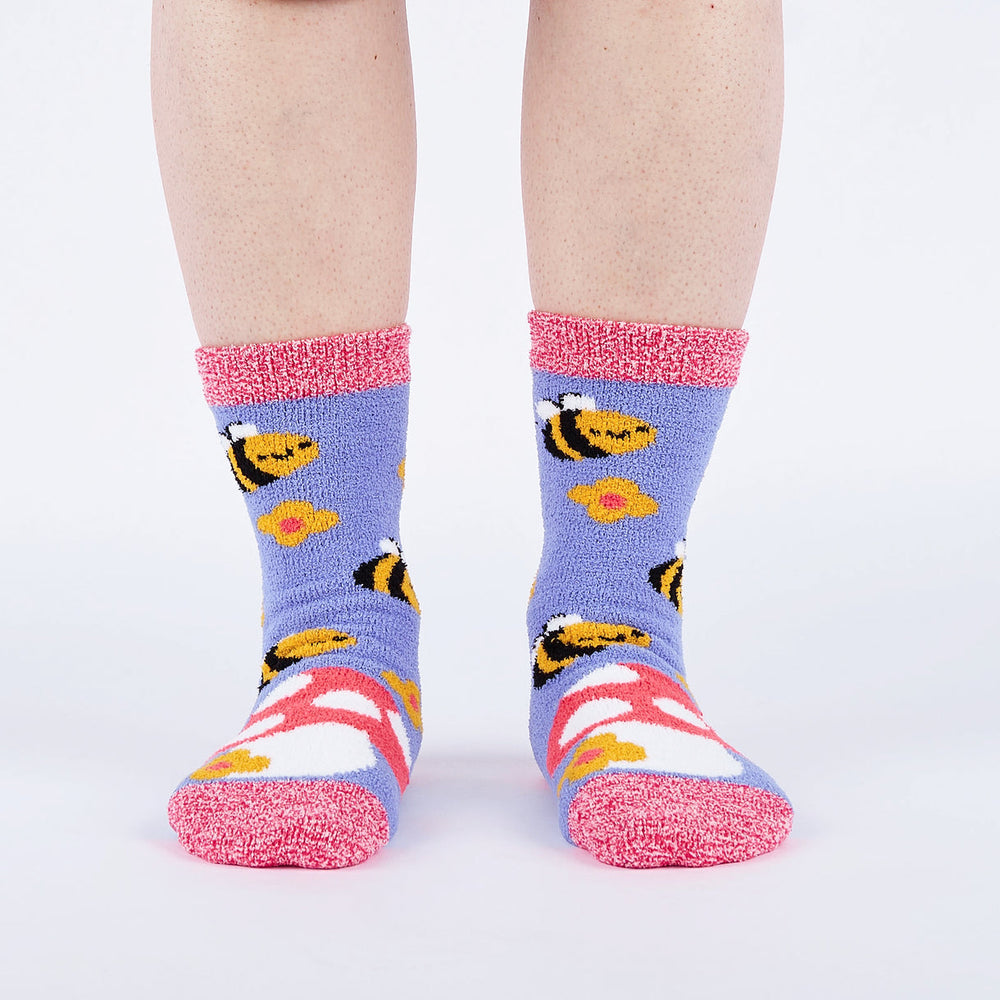 Women's fuzzy bee and mushroom slipper socks worn, front view with toadstool toe