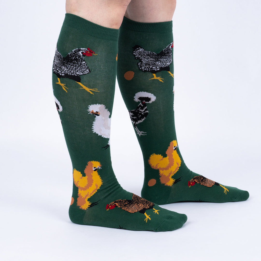 Women's chicken knee high socks worn, side view showing assorted hen breeds on green