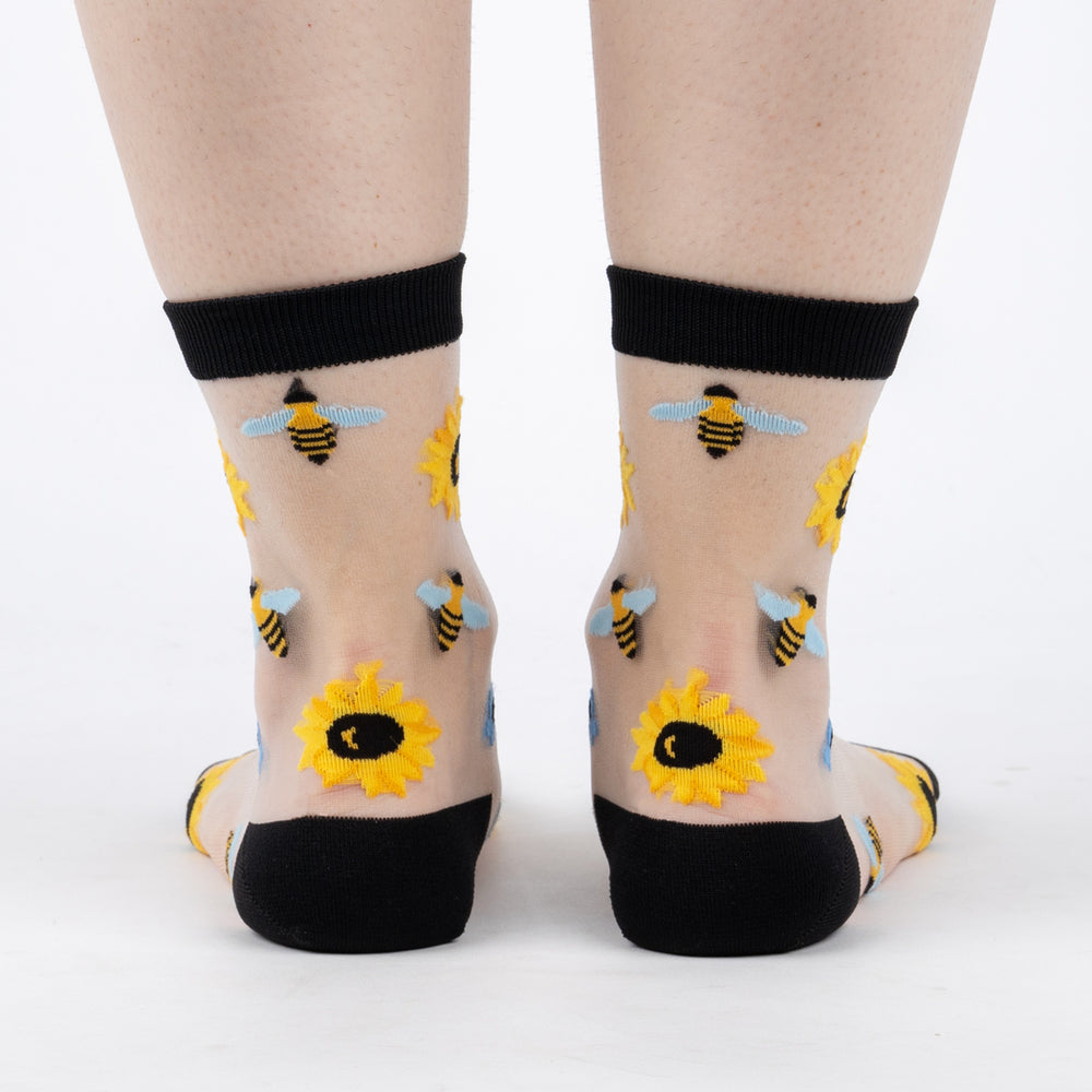 Women's sheer sunflower crew socks, clear mesh worn back view on legs