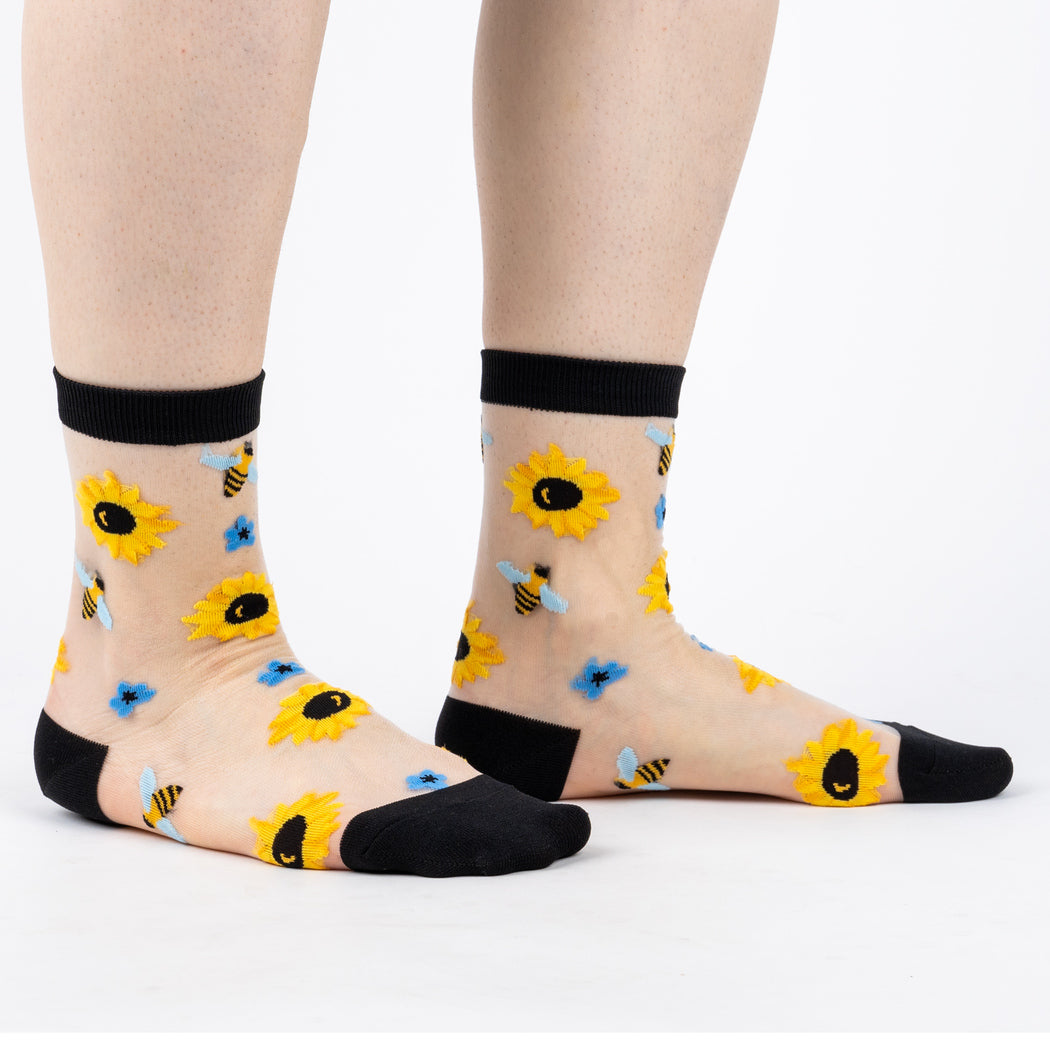 Women's sheer sunflower crew socks, clear mesh worn front view on legs