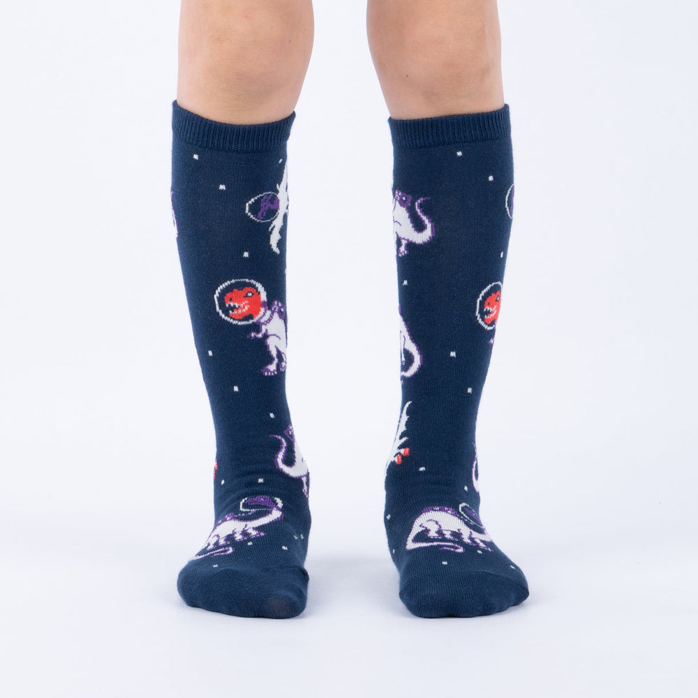 Kids' space dinosaur knee high socks worn, front view on child's legs