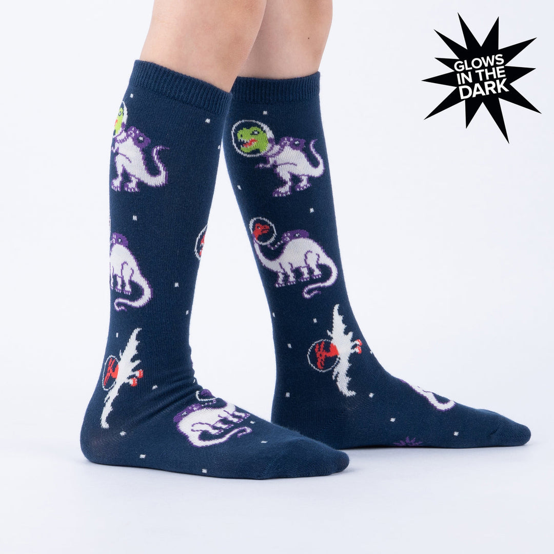 Kids' space dinosaur knee high socks worn, side view, glow-in-the-dark label