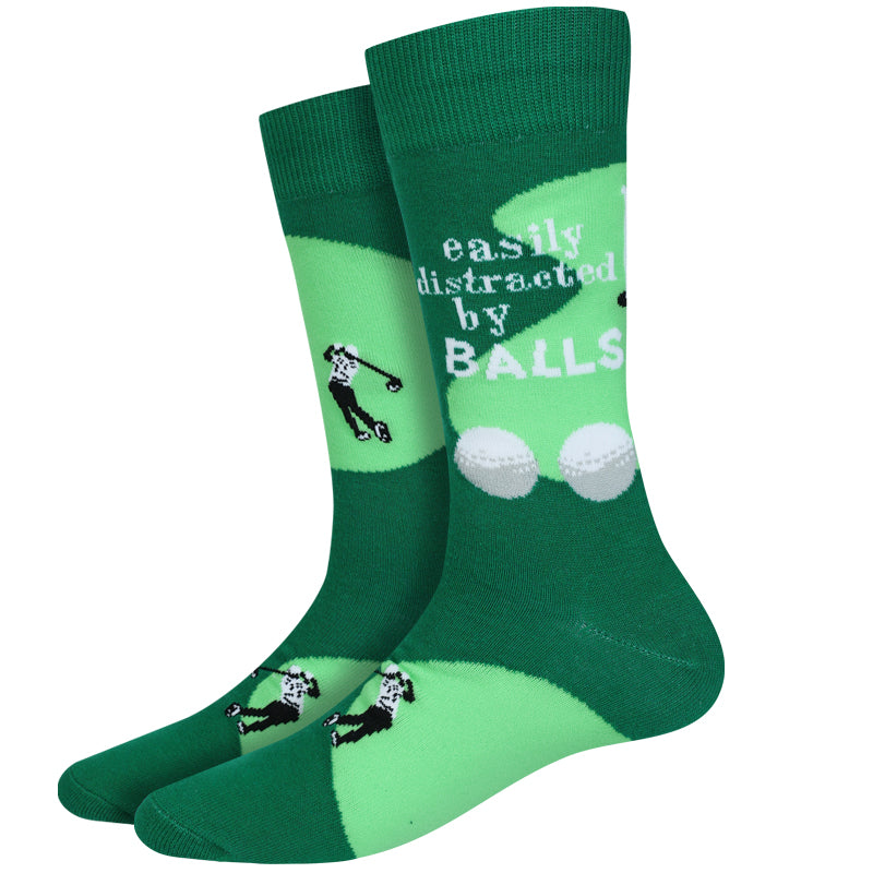 Men's golf crew socks, flat pair view with golfer silhouette, golf balls, and cheeky text on green