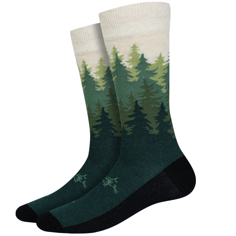 Men's forest skyline crew socks, flat pair view with ombre pine-tree forest fading to deep green