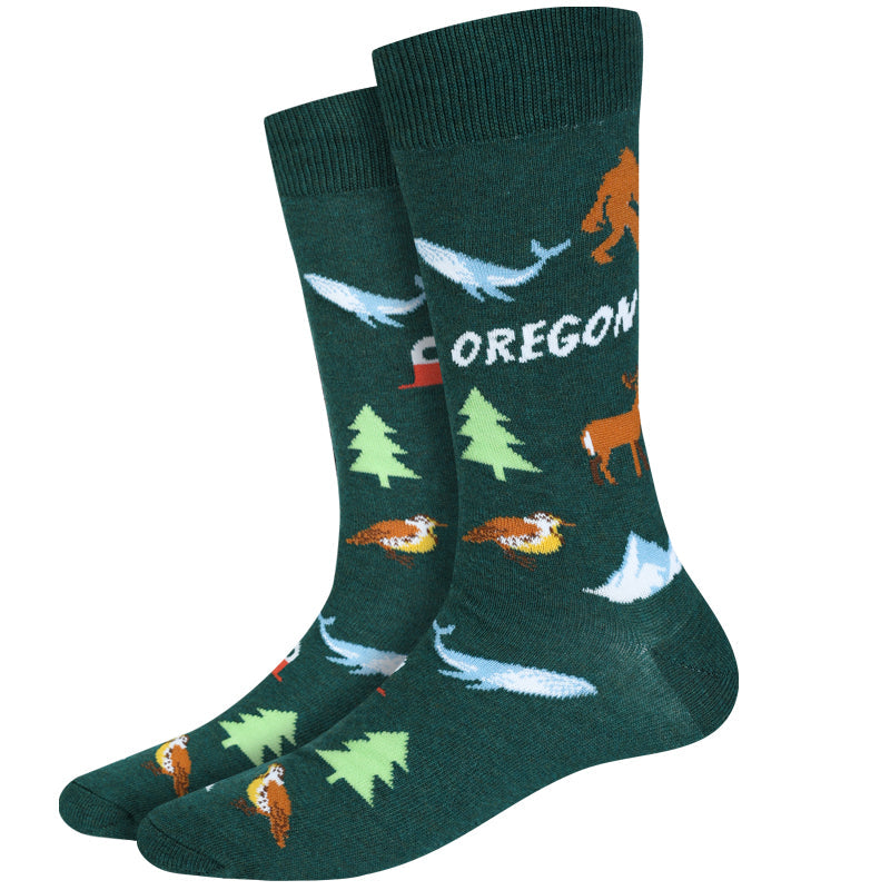 Men's Oregon crew socks, flat pair view with Bigfoot, whales, trees, and mountains on green