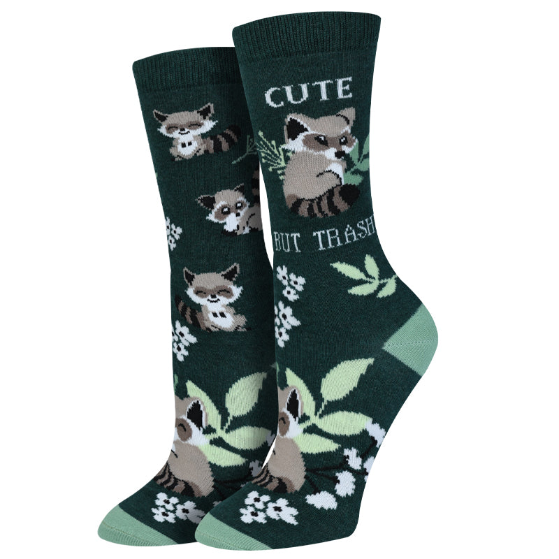 Women's forest green raccoon crew socks with "Cute But Trashy" text and flowers, flat lay pair