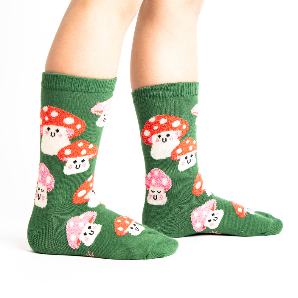 Kids' green mushroom youth crew socks, worn side view on child's legs