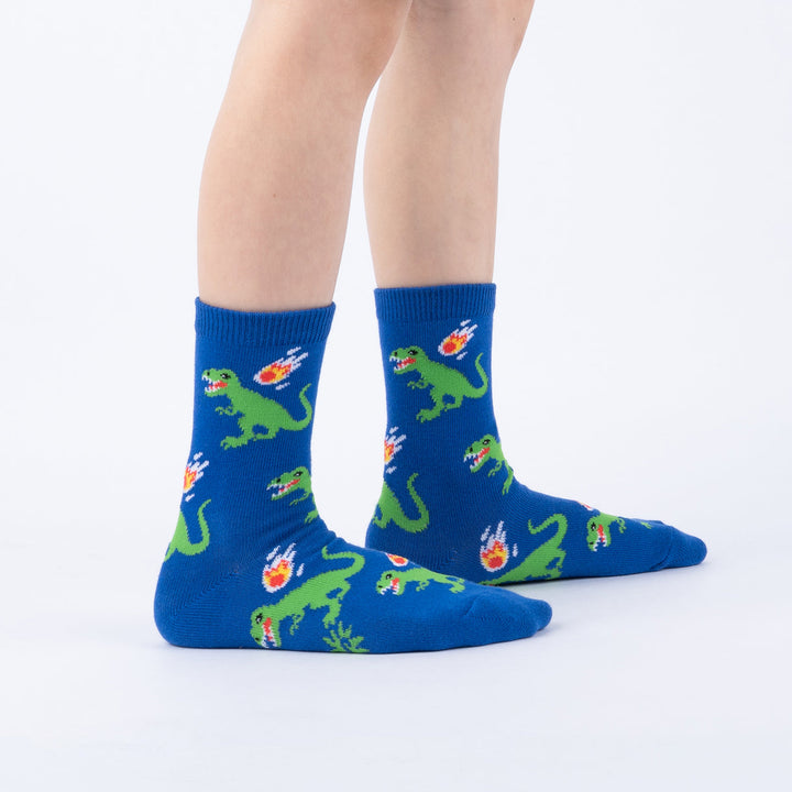 Child wearing blue T-rex and meteor junior crew socks, front view