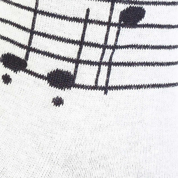 Close-up of women's music knee-high sock, black musical notes on staff lines