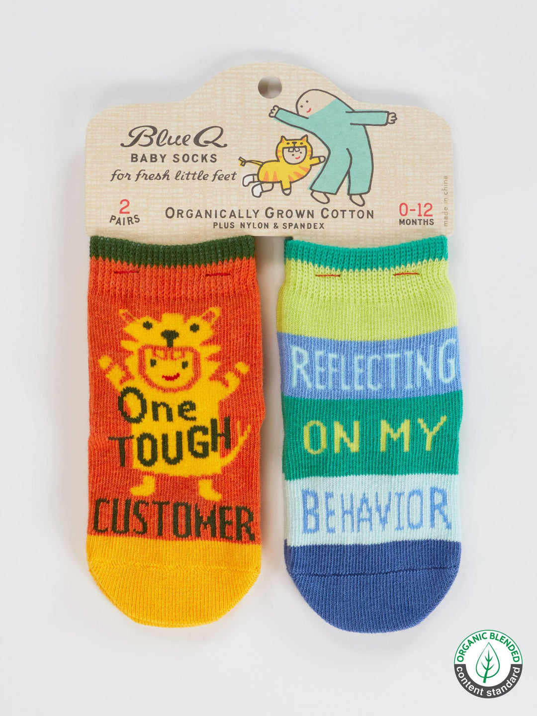 The Blue Q One Tough Customer/Reflecting On My Behavior Baby Socks set includes two pairs of colorful socks for babies 0-12 months—orange with a lion and green/blue striped—perfect for newborns.