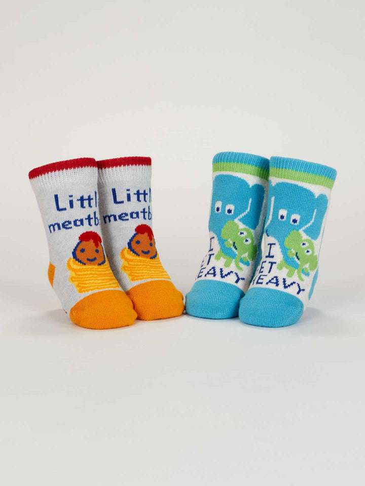 The Blue Q Little Meatball/I Get Heavy Baby Socks set includes two pairs of organic cotton socks—one orange/yellow meatball design and one blue/green elephant style—adding a cute touch to your little one&