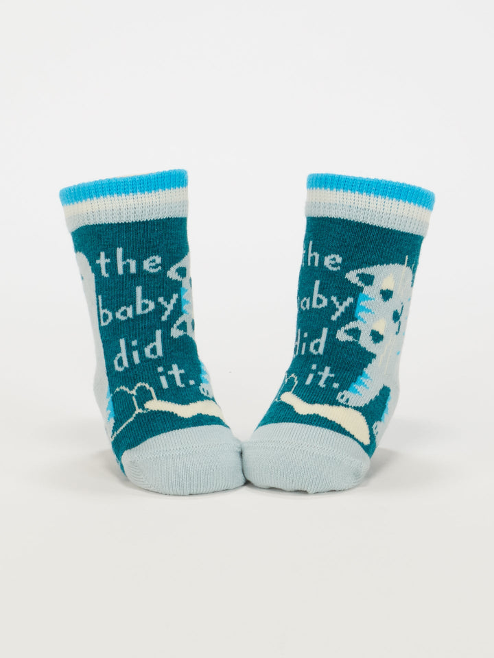 Blue Q’s Cat Lover Jr./The Baby Did It. Baby Socks are blue and white organic cotton baby socks featuring a playful sheep design and “the baby did it” on the front, shown upright on a plain white background.