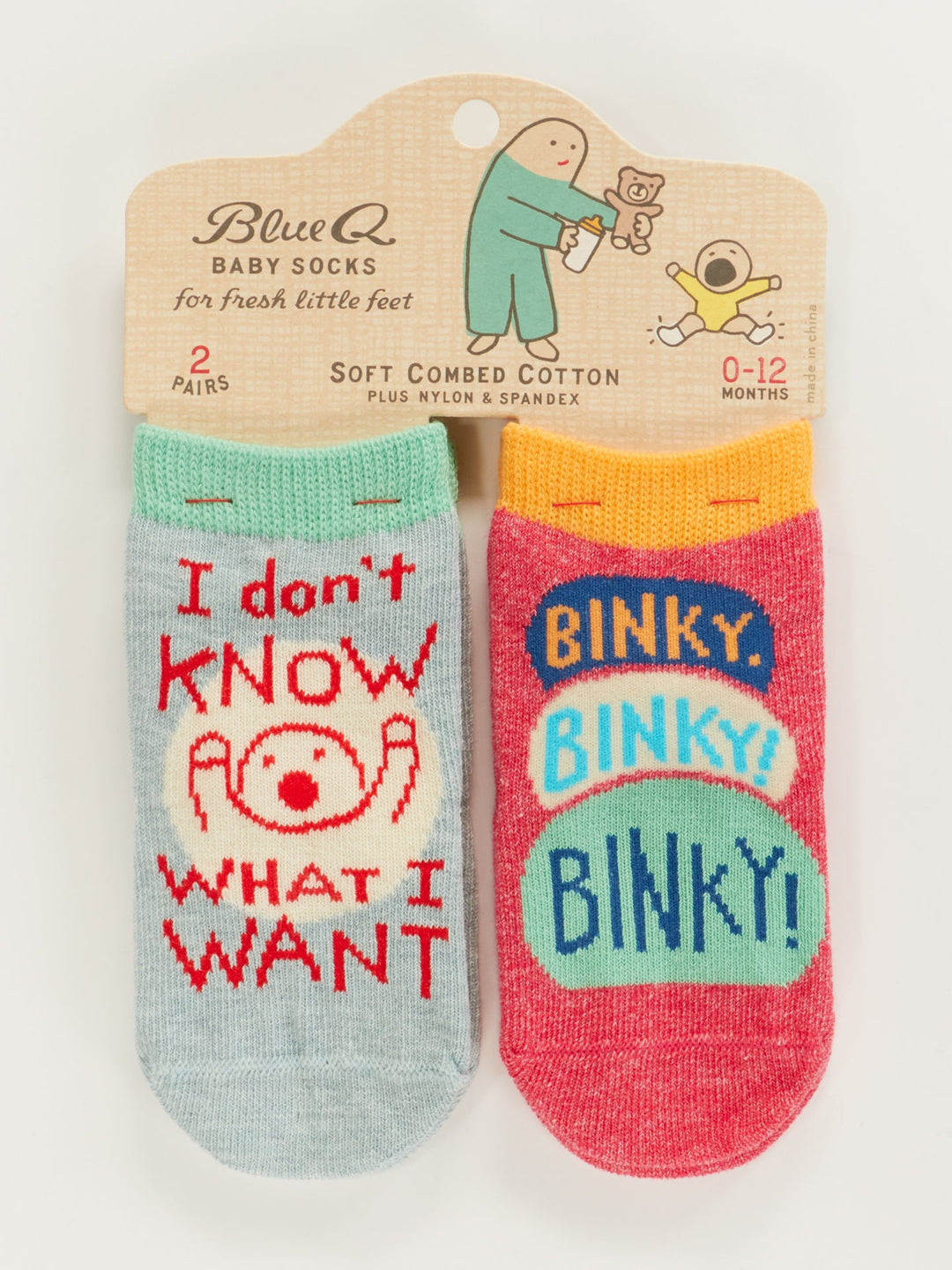 Blue Q "I Don't Know What I Want/Binky! Binky! Binky!" Baby Socks: two pairs for 0-12 months on a hanger—one light blue with cartoon baby and text, one red with colorful “BINKY!” pattern.