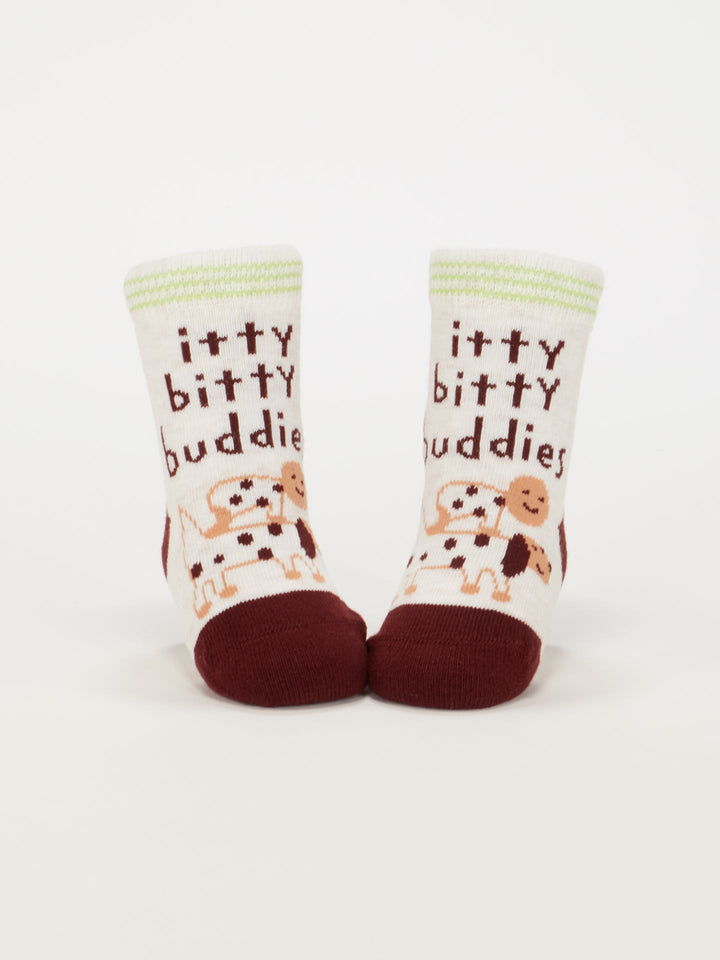 Blue Q’s Dog Lover Jr./Itty Bitty Buddies Baby Socks: white organic cotton baby socks with maroon toes, cartoon dogs, and “itty bitty buddies” in brown text for babies 0-12 months, shown on a plain white background.