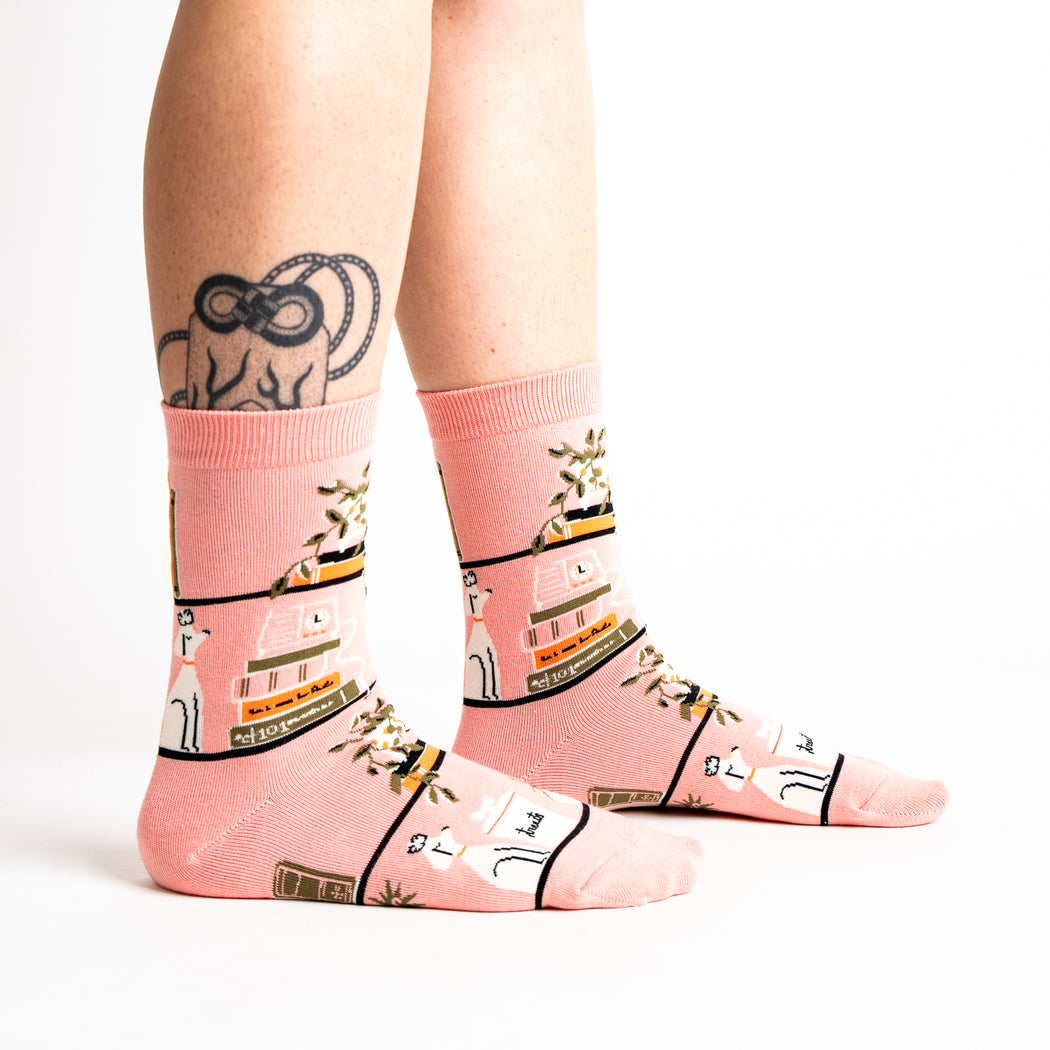 Women's bookshelf crew socks in blush pink, worn side view on legs
