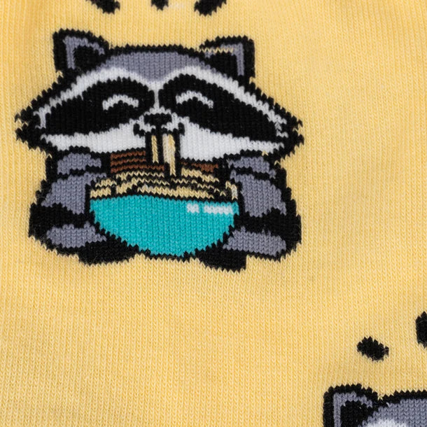 Close-up of women's raccoon crew sock, raccoon slurping a teal bowl of ramen