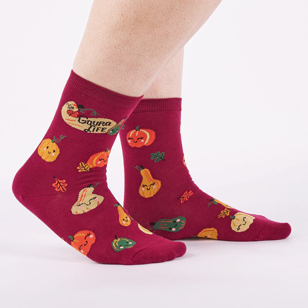 Women's autumn gourd crew socks worn, side view on wine-red background