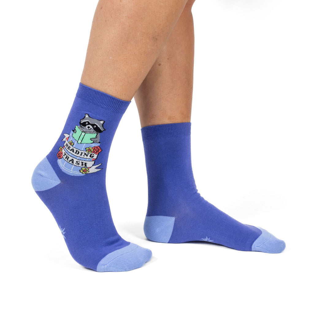 Reading Trash women's crew socks with a raccoon reading a book, model side view