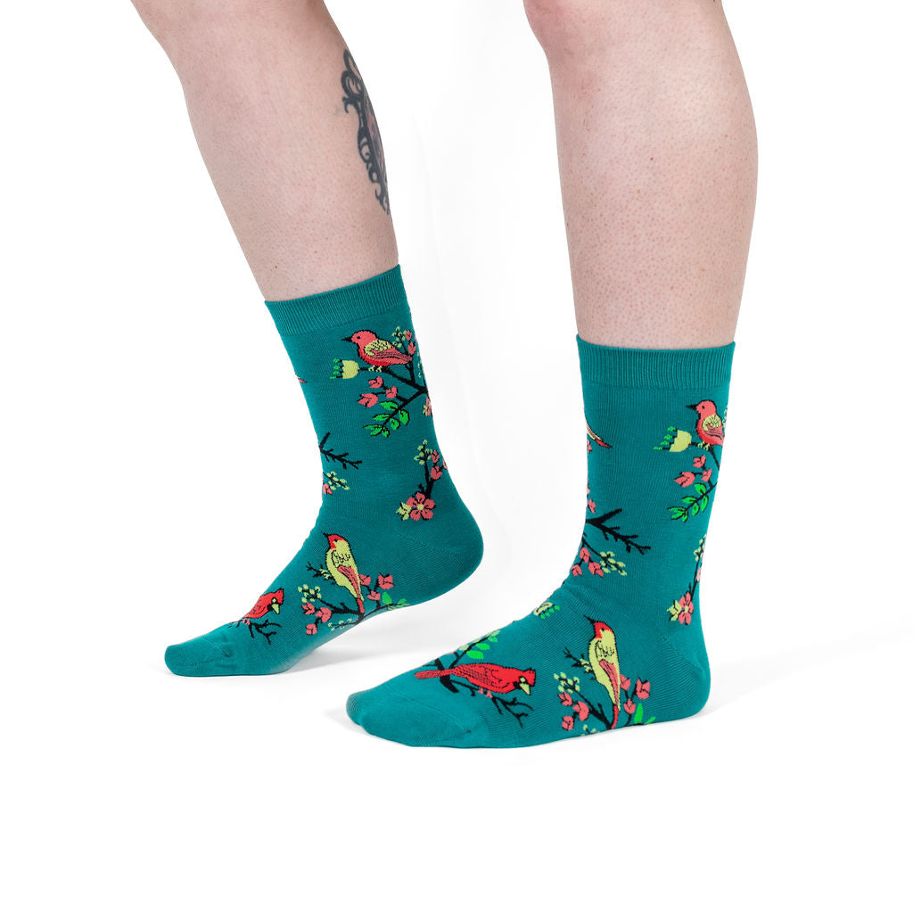 Always Peckish women's crew socks with perched songbirds, model side view