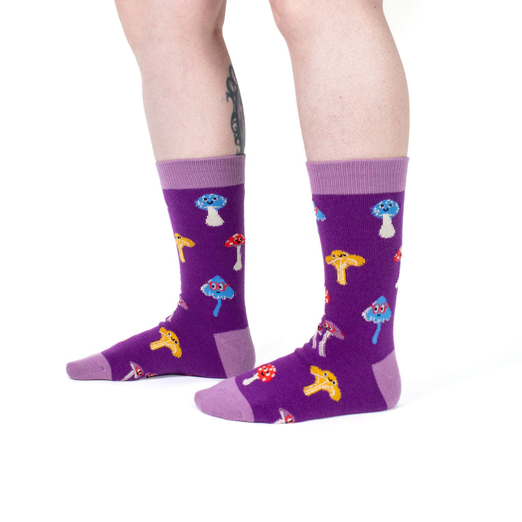 Happy Shrooms unisex wool crew socks with smiling mushrooms, model side view