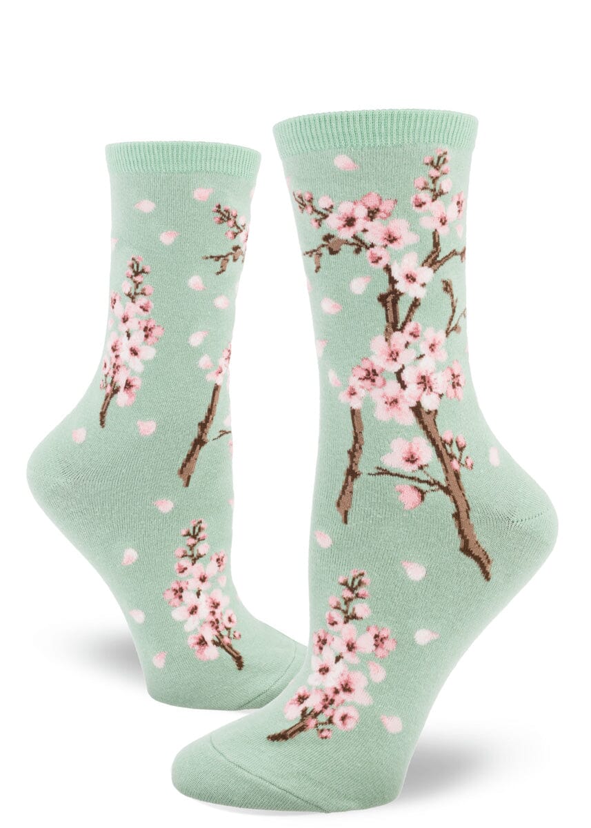 Women's cherry blossom crew socks in sage green with pink blossoms, flat lay