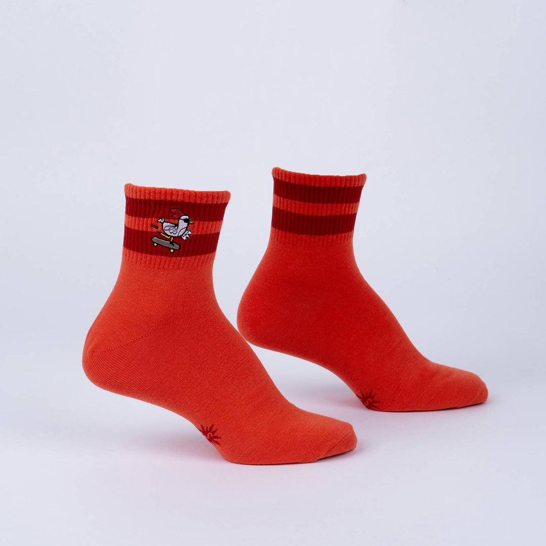 Men's skateboarding chicken quarter crew socks in orange with embroidered patch and red stripes, flat pair shot