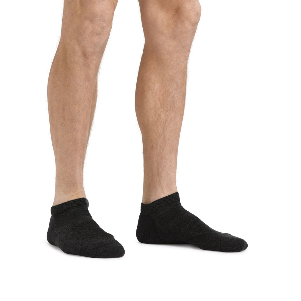 Men's black no-show socks worn on both feet, front view