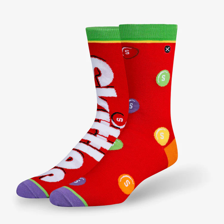 Men's Skittles crew socks angled flat lay with candies and logo on red, green and purple