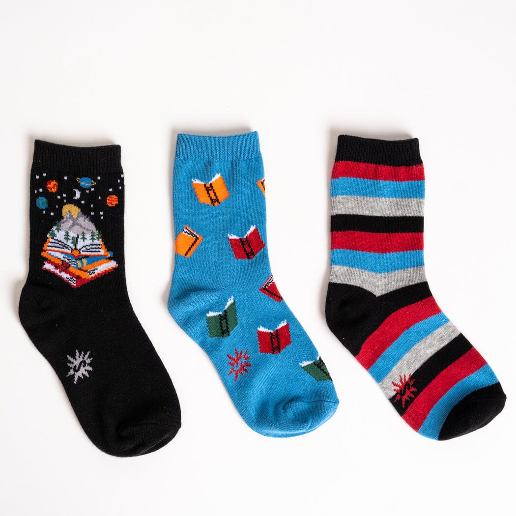 Kids' book crew socks 3-pack laid flat, showing storybook galaxy, falling books and striped designs