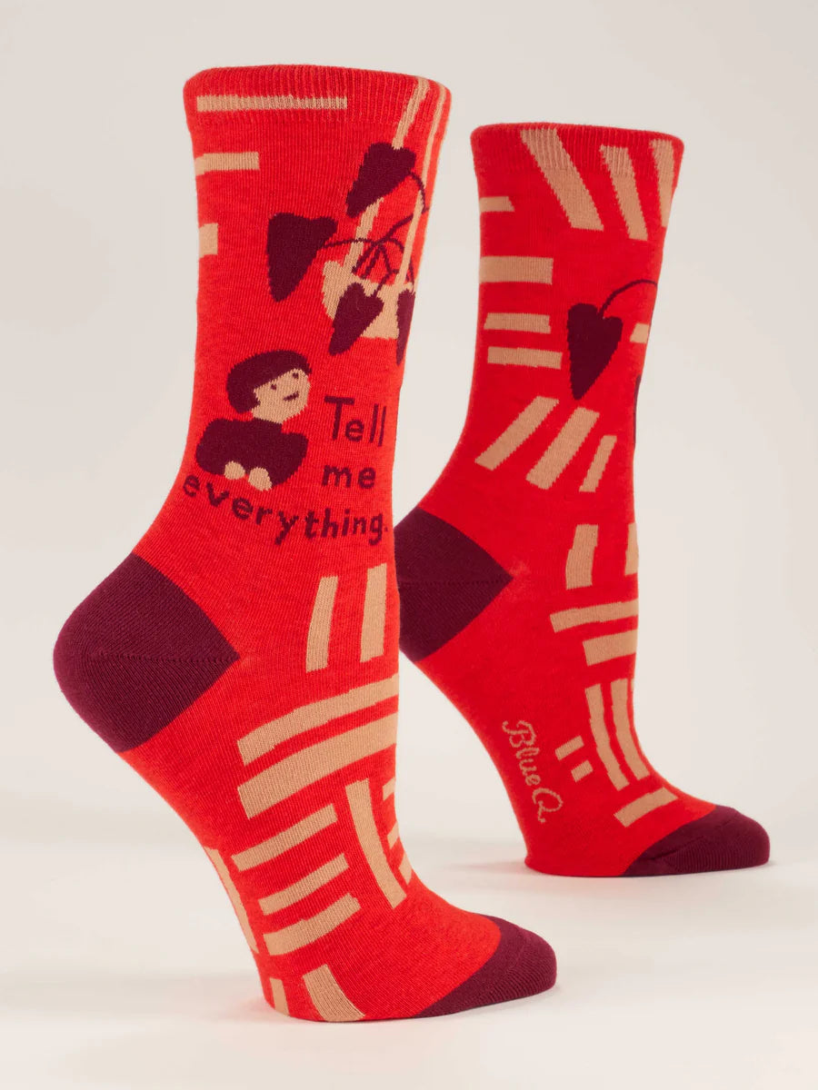 Women's Tell Me Everything crew socks, flat side view in red with cartoon figure and hearts
