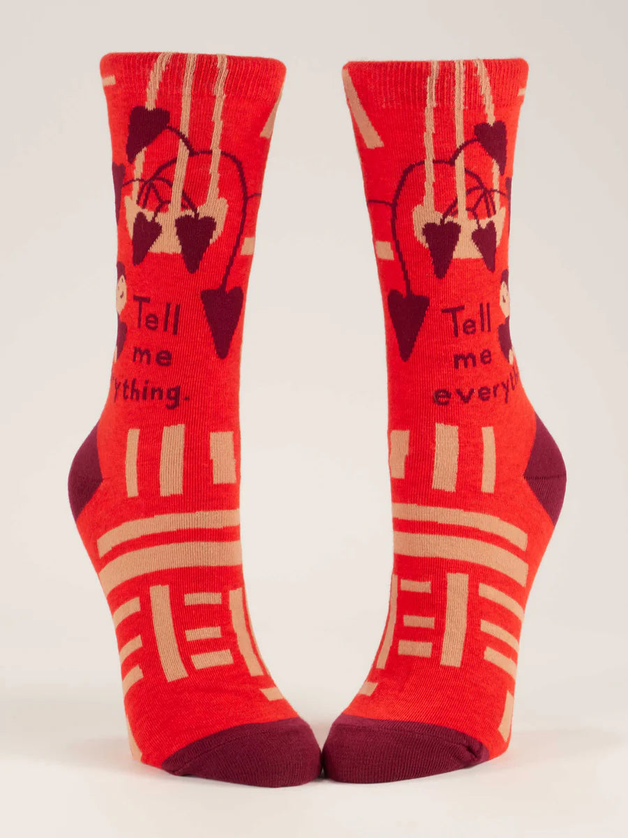 Women's red Tell Me Everything crew socks, flat front view showing tan geometric bars and maroon toes