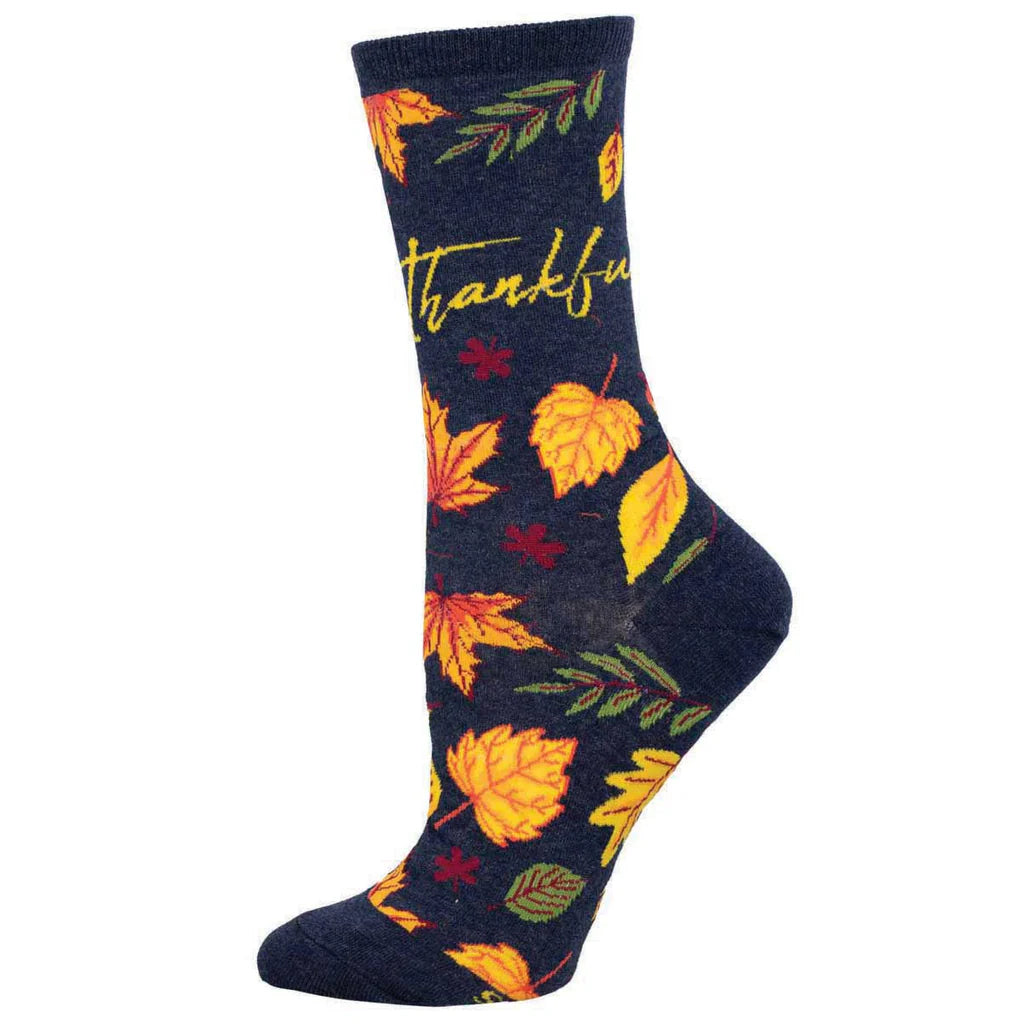 Women's fall leaves crew socks in navy with autumn leaves and thankful script, worn on foot