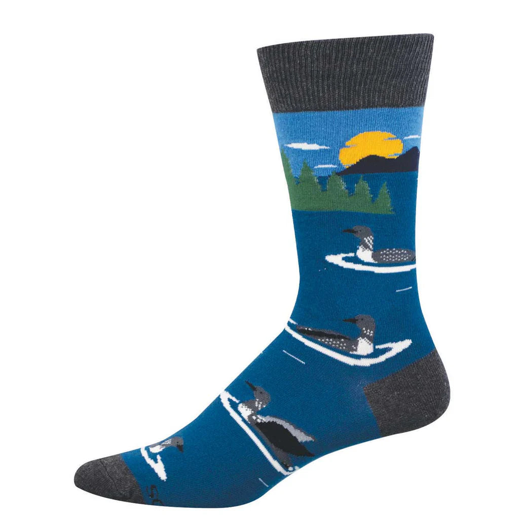 Men's loon crew socks flat lay in blue with loons on a lake and evergreen treeline