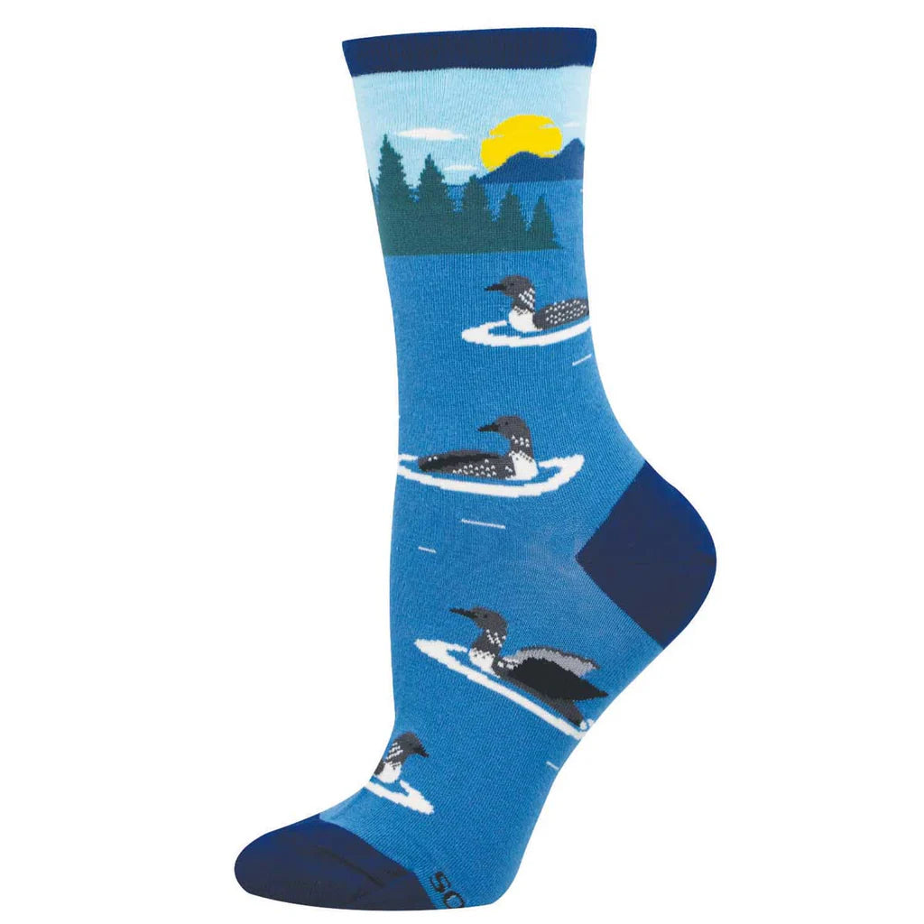 Women's loon crew socks laid flat, blue with black and white loons on a lake, forest shore, and setting sun