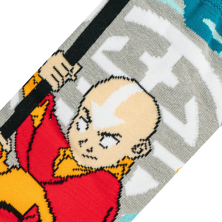 Close-up of Aang gripping his staff in orange robes against gray sock fabric with white arrow detail