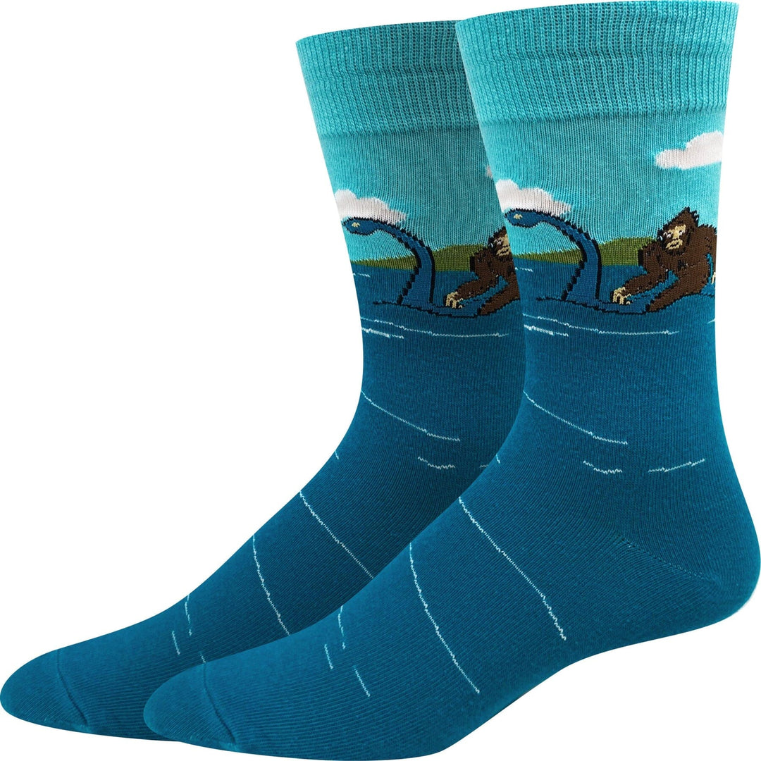 Unisex Bigfoot and Loch Ness Monster crew socks, flat front view with Sasquatch and Nessie at a teal lake