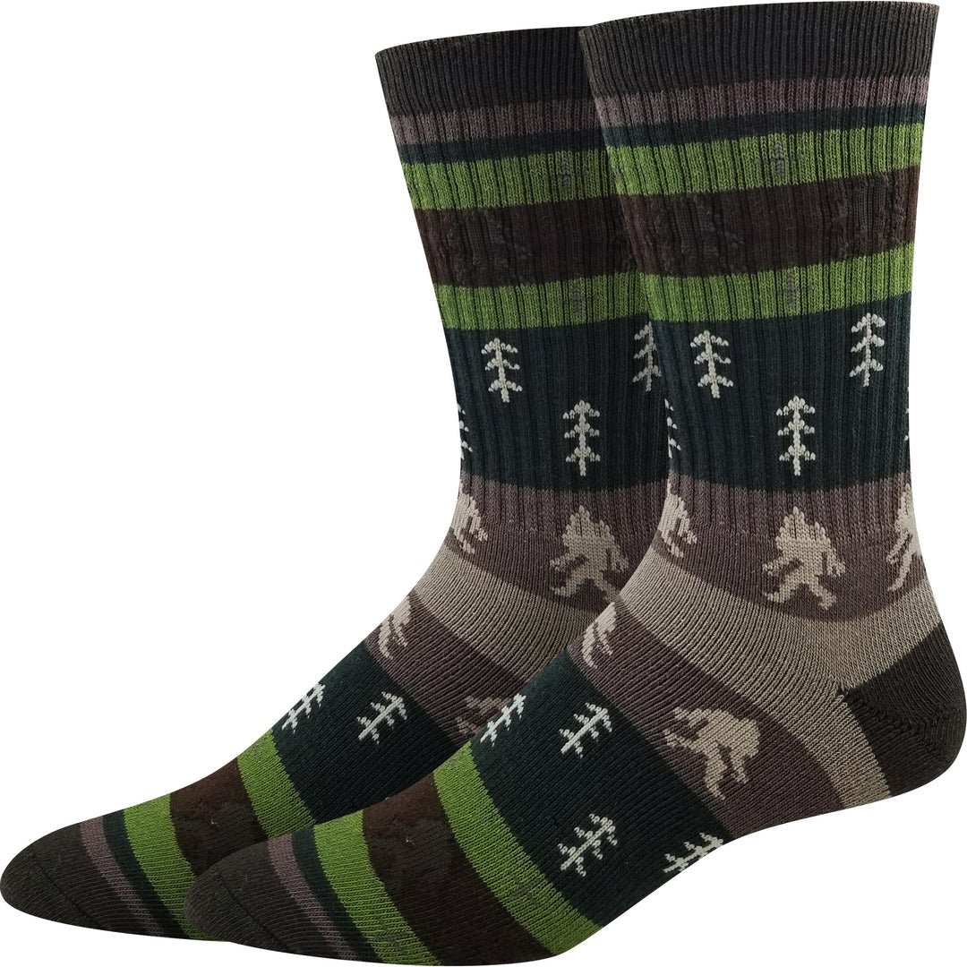 Pair of men's striped active crew socks in green and brown with cream pine trees and Bigfoot silhouettes