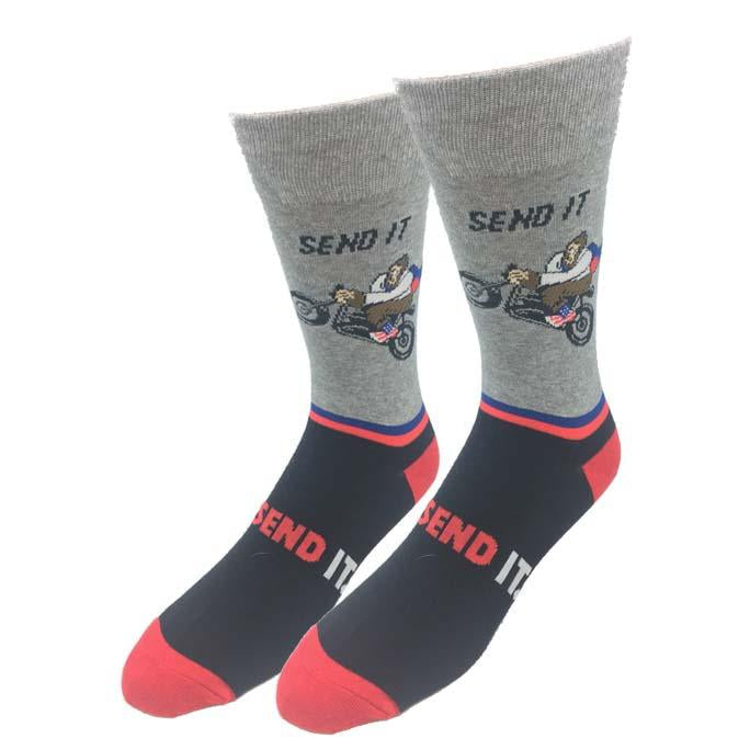 Pair of gray and black unisex crew socks showing Bigfoot doing a wheelie on a motorcycle with Send It text