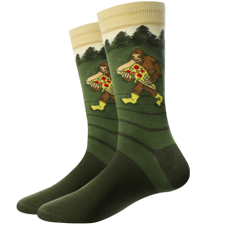 Pair of green Pizza Bigfoot crew socks displayed flat, with a cream cuff and a Sasquatch in yellow boots carrying a large pizza in the forest