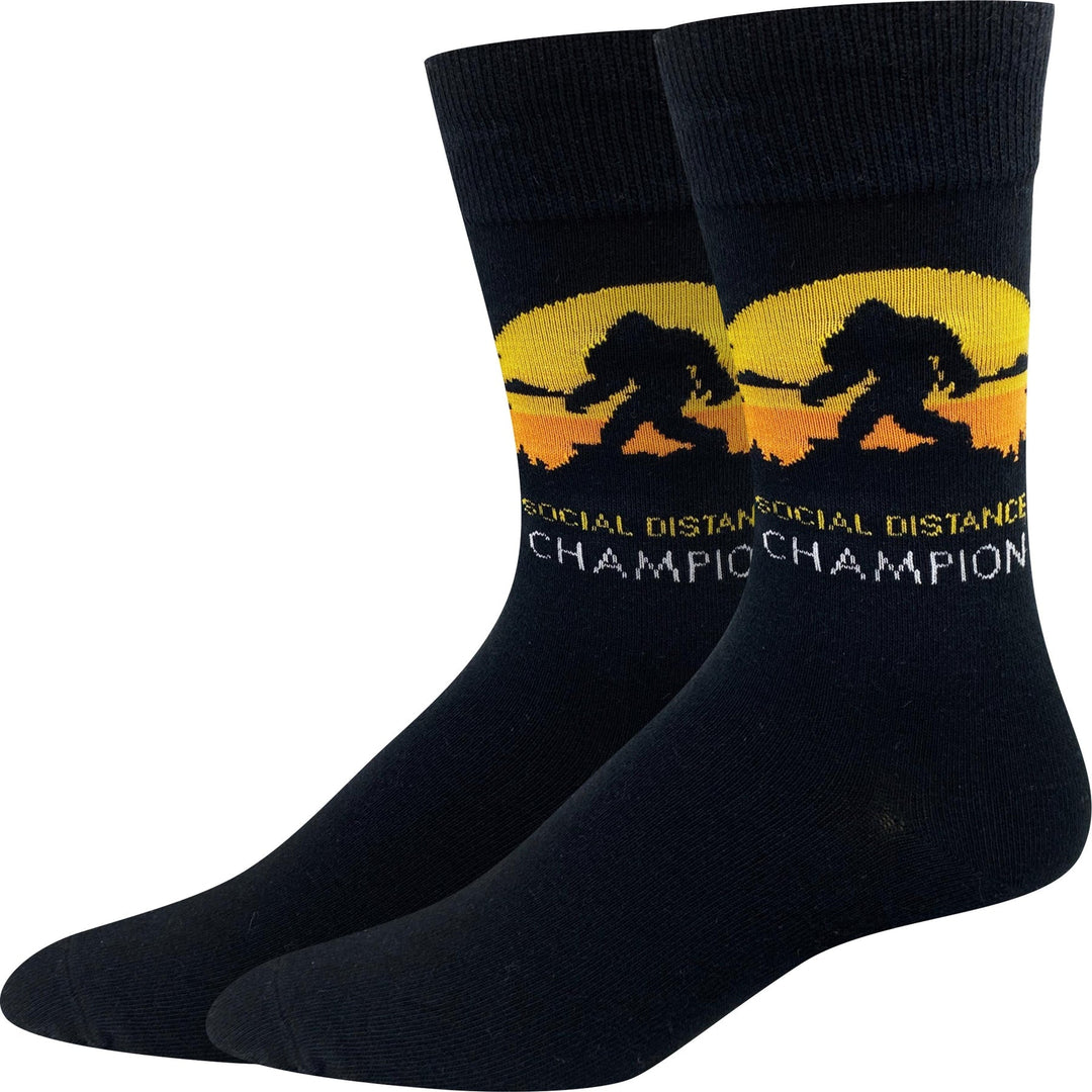 Pair of black unisex crew socks with a yellow sunset, Bigfoot silhouette, and Social Distance Champion text